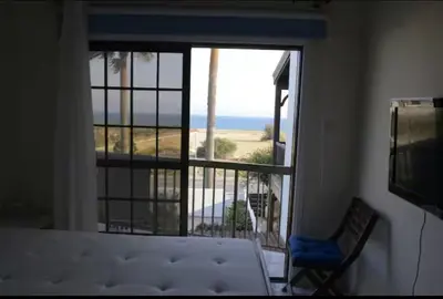 a bedroom with a bed and a view of the ocean at Sea view maisonette on coastal road, Zygi in Zygi