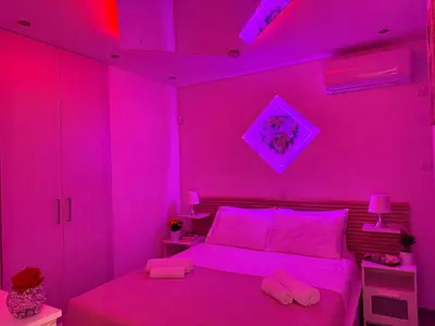 a pink bedroom with a bed with pink lighting at Lights of Paradise - Your Happy Escape in Ayia Napa