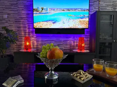a bowl of fruit on a table in front of a tv at Lights of Paradise - Your Happy Escape in Ayia Napa
