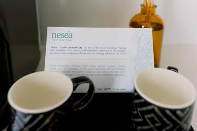 two cups of coffee next to a piece of paper at Nesea Seaside Luxury Escape in Paralimni