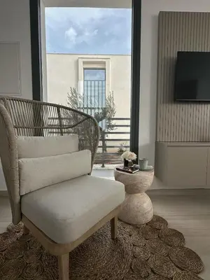 a living room with a chair and a large window at Nesea Seaside Luxury Escape in Paralimni