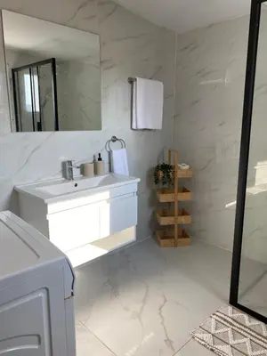 a white bathroom with a sink and a mirror at Barbaras House in Kato Pyrgos