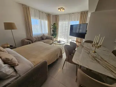 a bedroom with a bed and a table with a tv at Beach Front View Apartment Sea Pool & Prime Location in Limassol