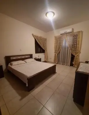 a bedroom with a bed and a window with curtains at Maria's Garden House in Pelendri