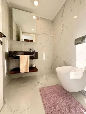 a bathroom with a sink and a toilet and a mirror at Brand new 2 bedrooms apartment in Grand Sapphire in İskele