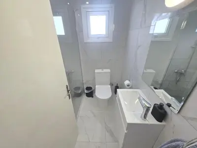 a white bathroom with a toilet and a sink at 1 bedroom, Agia Napa 1 - C in Ayia Napa