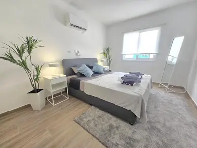 a bedroom with a large bed with blue pillows at 1 bedroom, Agia Napa 1 - C in Ayia Napa