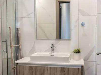 a white bathroom with a sink and a mirror at Mythical seas 004 in Paralimni