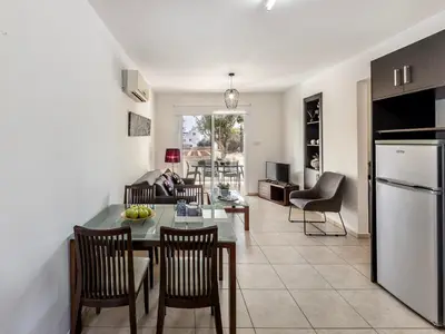 a kitchen and living room with a table and chairs at Mythical Sands CB04 in Paralimni