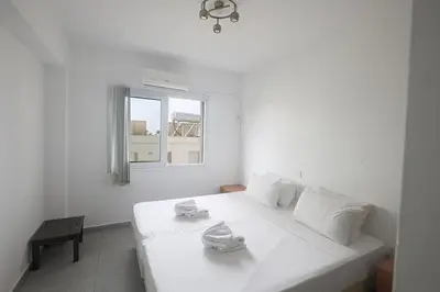 a white bed in a white room with a window at Napa Apollo 's Nest in Ayia Napa