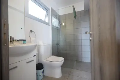 a white bathroom with a toilet and a sink at Napa Apollo 's Nest in Ayia Napa