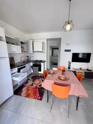 a kitchen with a table and chairs in a kitchen at Orange Sunset Duplex Lapta 2 bedrooms close to Merit Casino in Meniko