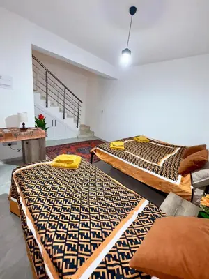 a room with two beds and a table at Orange Sunset Duplex Lapta 2 bedrooms close to Merit Casino in Meniko
