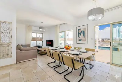 a dining room and living room with a table and chairs at Fig Tree Beach villa Three in Protaras