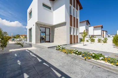 a white building with flowers in front of it at Villa Levanda #40 in Paralimni