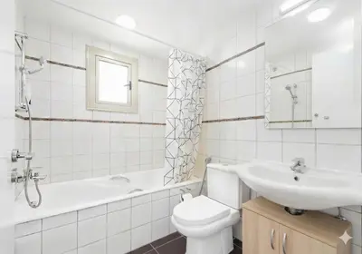 a white bathroom with a sink and a toilet at Fig Tree Beach Villa Four in Protaras