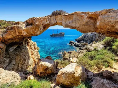 an archway with a boat in the water at Fig Tree Beach Villa Four in Protaras