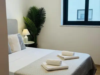 a bedroom with a bed with two towels on it at Makenzie View Penthouse in Larnaka
