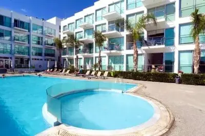 a large swimming pool in front of a building at Beachfront Seaview Apartment in Paralimni
