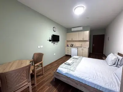 a bedroom with a bed and a table and a kitchen at Room in EkinAdademir Dorm North Cyprus in Nicosia