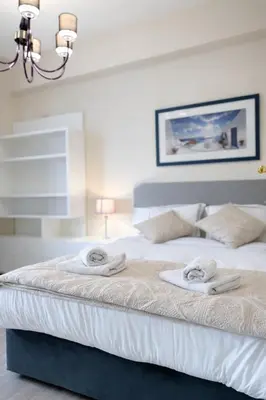 a bedroom with a bed with towels on it at Gulf Beach Apartment by TrulyCyprus in Limassol