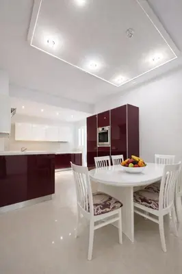 a white kitchen with a white table and chairs at Gulf Beach Apartment by TrulyCyprus in Limassol