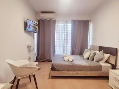 a bedroom with a large bed and a window at Olive studio in Limassol