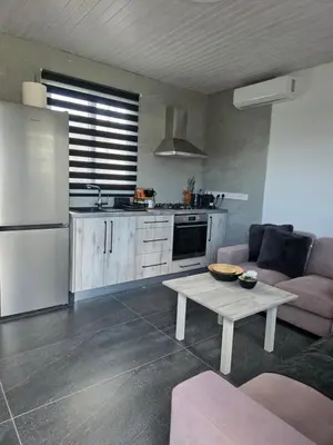 a kitchen with a white refrigerator and a table at Relaxing small home