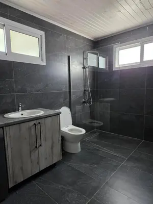 a bathroom with a toilet and a sink and a shower at Relaxing small home