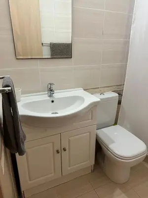 a bathroom with a sink and a toilet and a mirror at Натали апарт in Paralimni