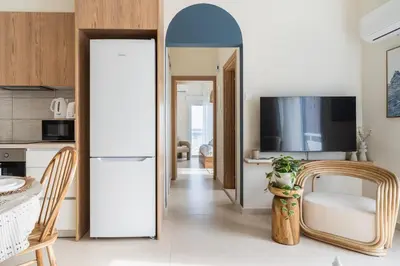 a kitchen with a white refrigerator and a table at Compass 1-Bedroom Apartment in Larnaka