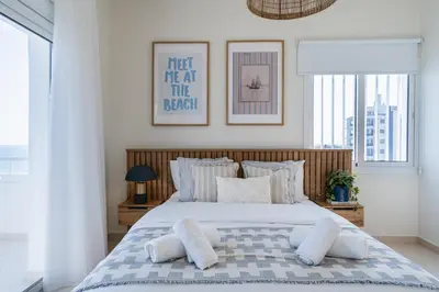 a bedroom with a bed with pillows on it at Compass 1-Bedroom Apartment in Larnaka