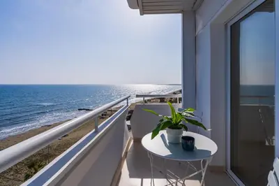 a balcony with a table and a view of the beach at Compass 1-Bedroom Apartment in Larnaka