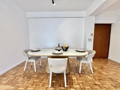 a white dining room with a table and chairs at STAY Aelia Apartment in Nicosia