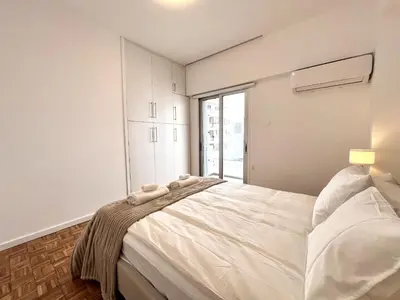 a bedroom with a large white bed with a window at STAY Aelia Apartment in Nicosia