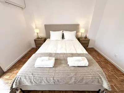 a bedroom with a large bed with two towels on it at STAY Aelia Apartment in Nicosia
