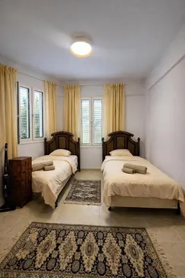 a bedroom with two beds and a rug at Modern Seaside Apartment Steps to the Beach in Pervolia