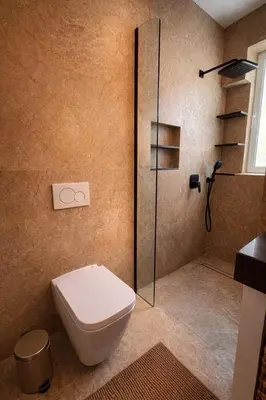 a bathroom with a toilet and a glass shower at Modern Seaside Apartment Steps to the Beach in Pervolia