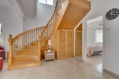 a hallway with a wooden staircase in a house at Oceanic Pearl Villa Deluxe - 200m from beach in Voroklini