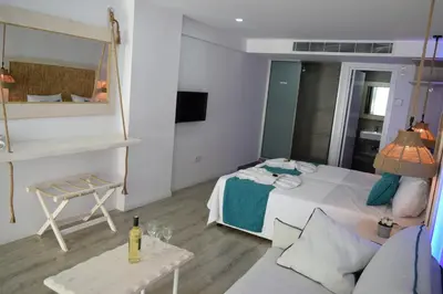 a room with a bed and a couch and a mirror at Seaside Stay Room in Ayia Napa