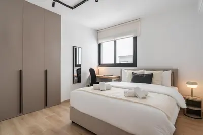 a white bedroom with a large bed and a desk at Aoki 3-Bedroom Luxury Apartment in Limassol