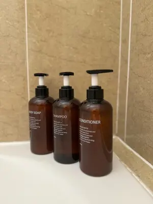 three bottles of soap are sitting on a shelf at NISSI ELENA Family Apt FREE WIFI in Ayia Napa