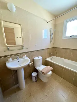 a bathroom with a sink and a toilet and a tub at NISSI ELENA Family Apt FREE WIFI in Ayia Napa