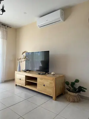 a living room with a flat screen tv on a entertainment center at NISSI ELENA Family Apt FREE WIFI in Ayia Napa