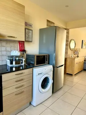 a kitchen with a washing machine and a refrigerator at NISSI ELENA Family Apt FREE WIFI in Ayia Napa