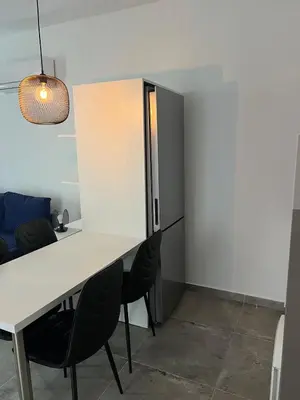 a dining room with a white table and black chairs at Sea view Appartment in Larnaka