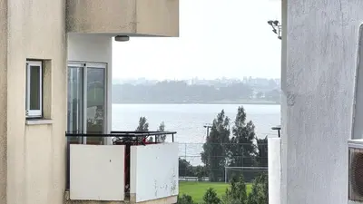 a balcony with a view of the water from a building at Warm Design 3BR, Beach 7-min walk, Peaceful in Larnaka