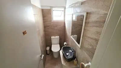 a small bathroom with a toilet and a mirror at 3BR Shared Apt - Beach 7-min walk, Peaceful in Larnaka