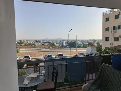 a balcony with a table and a view of a parking lot at 1 room at sharing flat in Larnaka