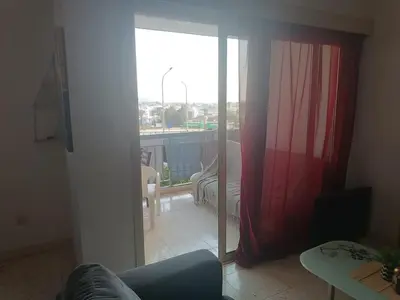 a living room with a sliding glass door to a balcony at 1 room at sharing flat in Larnaka